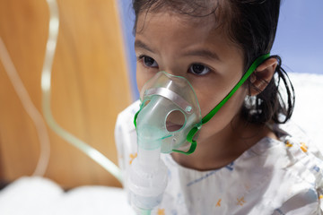 Asian child girl has asthma or pneumonia disease and need nebulization by get inhaler mask on her...