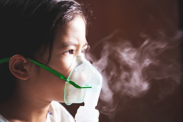 Asian child girl has asthma or pneumonia disease and need nebulization by get inhaler mask on her face - obrazy, fototapety, plakaty