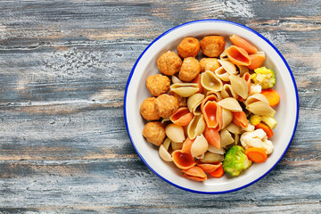 Meatballs with Conchiglie, broccoli and a cauliflower in a plate on a table. Diet food. Top view. Copy space