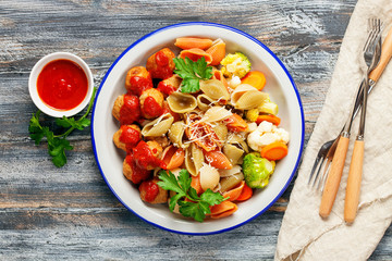 Meatballs with Conchiglie, broccoli and a cauliflower in a plate on a table. Diet food. Top view.