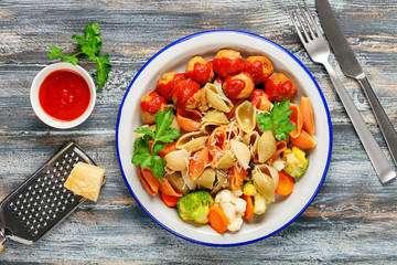 Meatballs with Conchiglie, broccoli and a cauliflower in a plate on a table. Diet food. Top view.