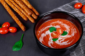 Tomato red soup sauce with olive oil on a wooden background.