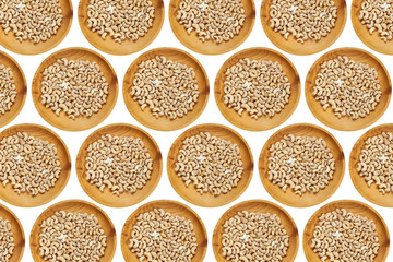Peeled cashew  in a wooden pine plate on a white isolated background. Row of bowls with cashew   nuts, top view. Peeled cashew  pattern