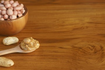 Peanut in wooden bowl on classic wooden table background, peanut butter