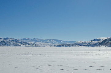 The wide open lake bed area under the bright sun light in the winter lake area of utah. 