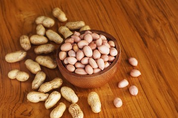 Peanut in wooden bowl on classic wooden table background, peanut butter