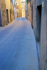 Fototapeta na wymiar Narrow street in historic center of Montalcino town, Val d'Orcia, Tuscany, Italy