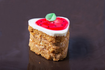 Delicious strawberry cake on a plate on a dark background.
