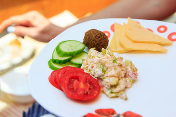 Breakfast food plate open buffet. Tomato, cucumber vegetables with cheese and falafel with salad, pancakes as dessert. Tasty healthy vegetarian morning meal dish, food photography closeup