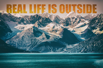 REAL LIFE IS OUTSIDE motivational quote on mountain range landscape background. Adventure message...