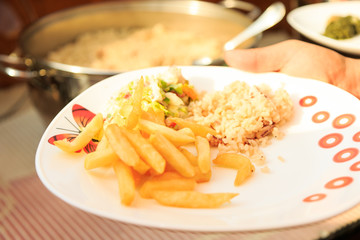 Breakfast food plate open buffet. Vegetables with cheese and falafel with salad, rice and french potato fries. Tasty healthy vegetarian morning meal dish, food photography closeup