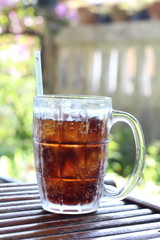 glass of water with ice cubes on wooden table