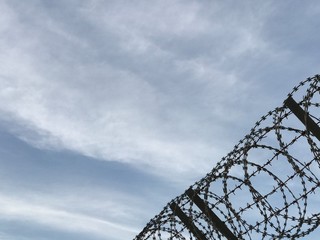 Metal fence wire, War and sky in the background Silhouette in Phuket Thailand