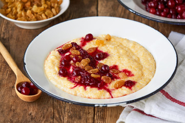 Corn porridge with cranberry jam and raisins