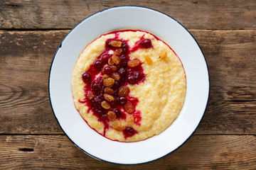 Corn porridge with cranberry jam and raisins