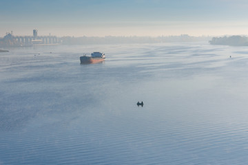 Cargo ship in fog on a river Dnieper
