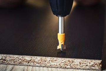 process of drillig wood with a drill bit close up