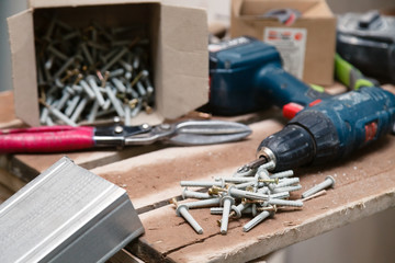 Closeup dusty construction building tools on the scaffolding, puncher, drill, perforator, screw in...