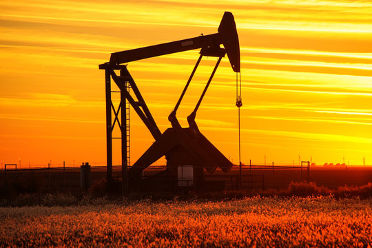 Pump Jack In The Oil Field At Sunset