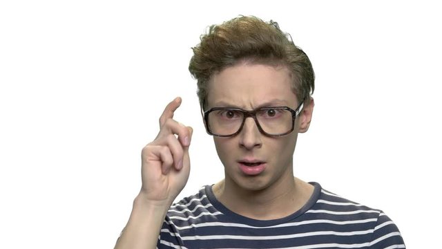 Surprised teenage boy wearing eyeglasses. Portrait of amazed caucasian nerd boy having an idea. Isolated on white background.