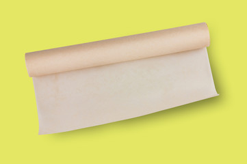 One roll of brown baker paper in center on yellow table on cuisine. Top view. Flat lay. Cooking concept