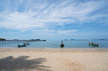 Fototapeta na wymiar beautiful scenery with wood boat on the beach white sand in blue sea and blue sky on tropical beach .