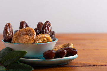 Dried figs and dates on a platter on a white background
