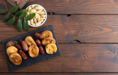 Dried figs and dates on a platter on a white background