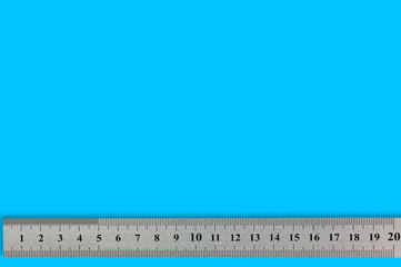 Single metal straightedge with digits and scale on blue background with copy space for your text
