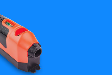 One red and black plastic laser level with water bubble for horizontal or vertical measure on blue...