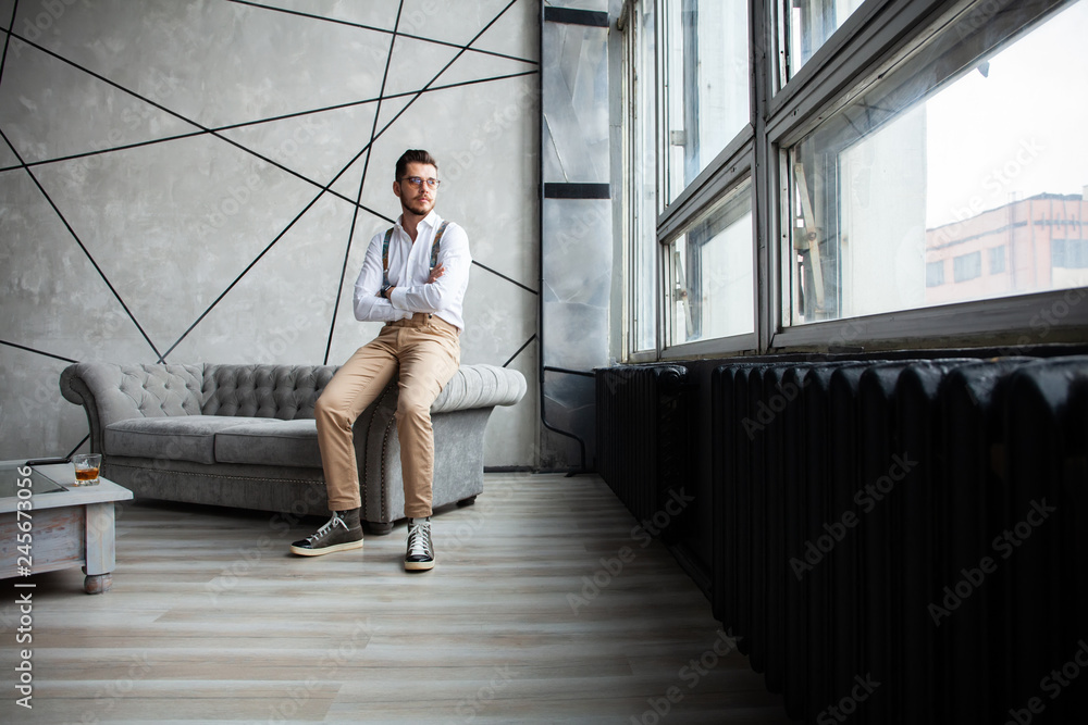 Wall mural he is looking into your heart. full length of thoughtful young man in white shirt and suspenders loo