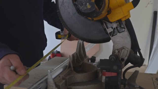 Craftsman sawing metal with disk grinder in sparks while grinding iron