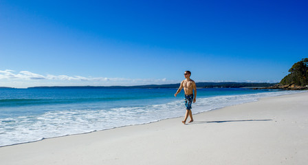 man walking on the white sands of Hyams Beach in Jervis Bay, Australia