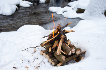 Campfire on snow in the winter forest
