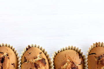 pastries for dessert. row of ruddy cupcakes with a crust on the table top view