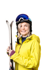 Smiling girl in helmet holding skis