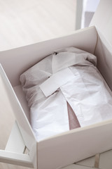 White opened box with wrapping paper and pink linen cloth. Copyspace for text