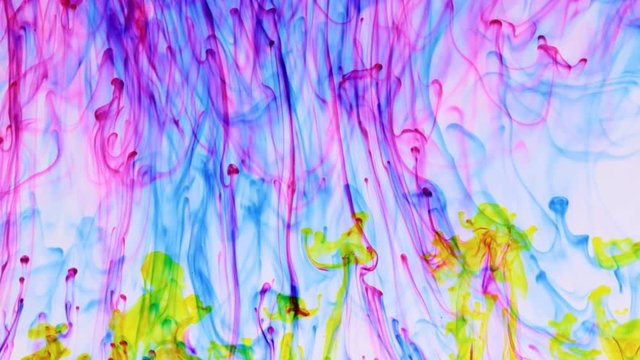 Yellow drops of ink on red,blue background. Colorful paint in dynamic flow.