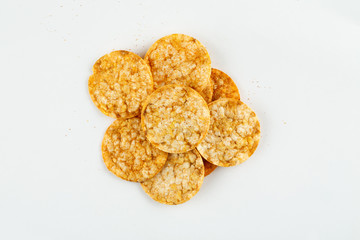 Whole grain corn and rice chips with paprika on a white background