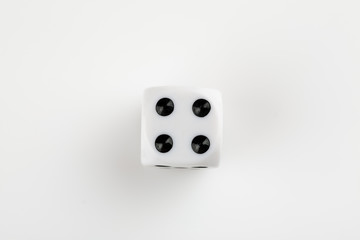 Single white with black dots dice on a white background, showing number four
