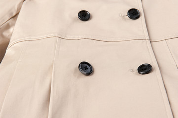 Beige trench coat button close-up
