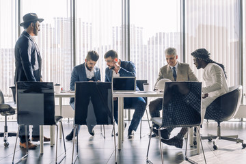 Serious Indian CEO in interacting with multiracial vendors at corporate meeting, explaining development project strategy, proving them to continue cooperation.
