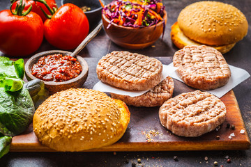 Ingredients for burgers on dark background, top view.