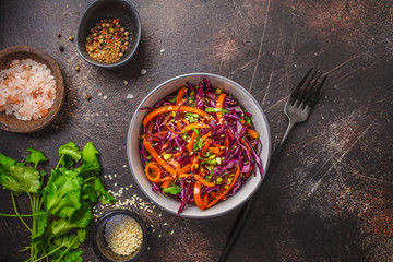 Coleslaw in a gray bowl on dark background. Red cabbage and carrot salad.