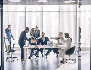 Creative friendly smiling businessmen having conversation sitting together at meeting, cheerful...