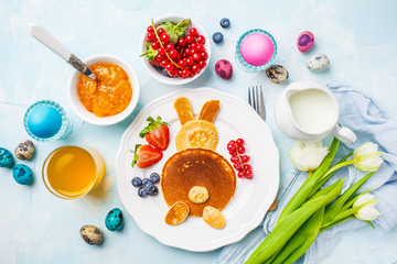 Easter bunny of pancakes with berries. Easter Breakfast table. Blue background, top view.