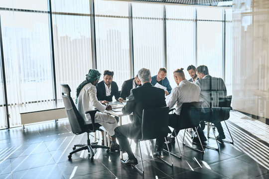 Hardworking Office Workers Are Ahving A Business Conversation In The Room With Panorama Window