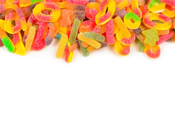 Frame of assorted gummy candies isolated on white. Top view. Space for text or design.