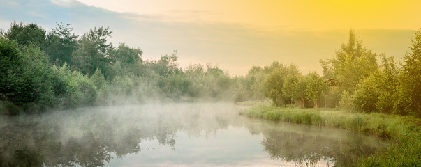 Fototapeta na wymiar Sunrise with mist over a lake at the wetlands