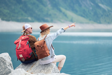 Travelers couple look at the mountain lake. Travel and active life concept with team. Adventure and...